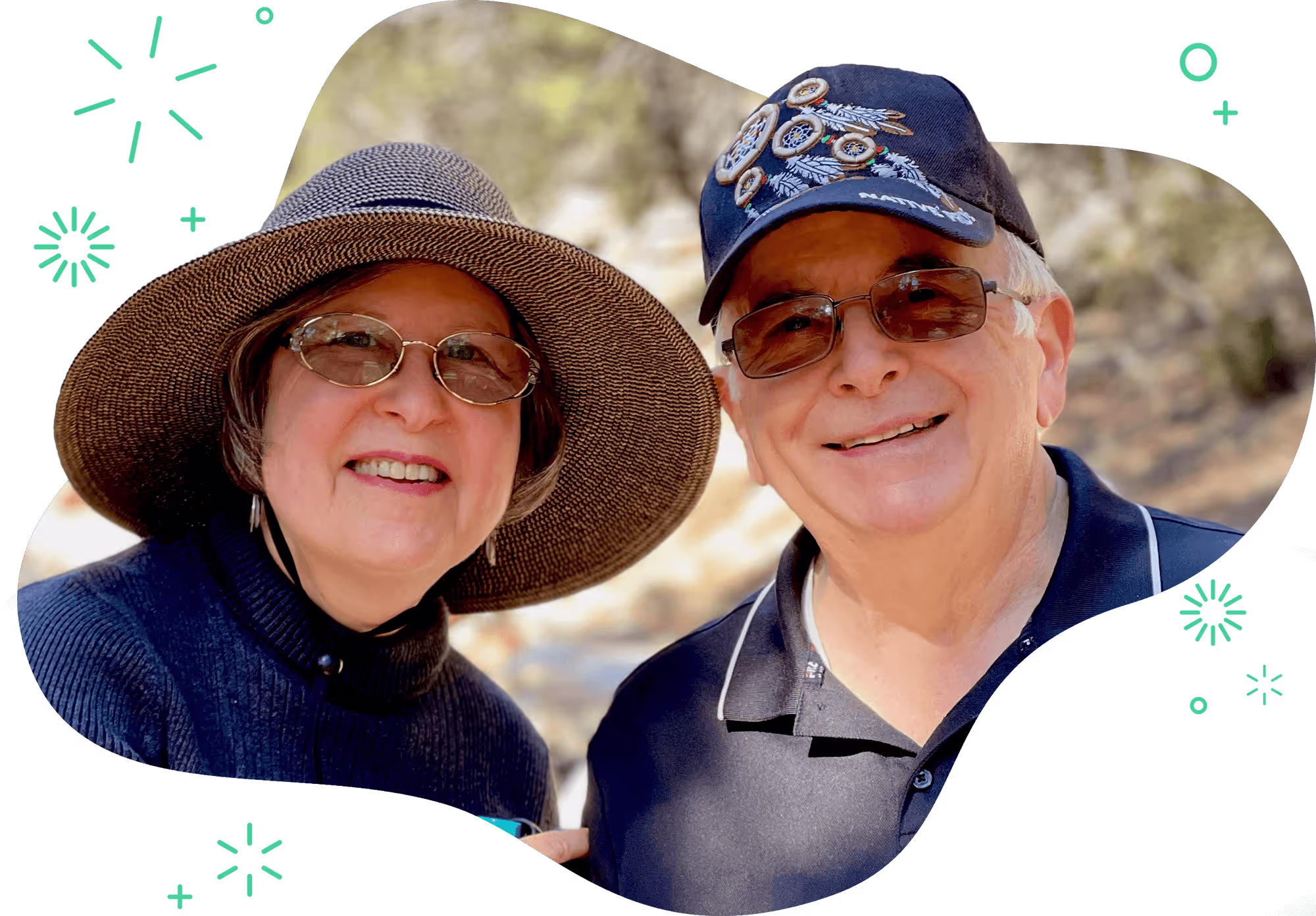 An elderly couple wearing hats outside smiling